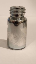 Three separate samples of Gallium. 1: "Rescue mission of gallium stuck in a tube." 2: "Gallium trying to 'escape' its cube (pressure from heat)." 3: "1g of gallium melted and completely covered bottle during transit."