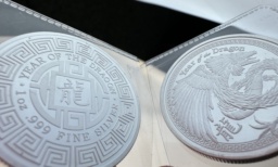 Two shiny silver coins with engravings of “year of the dragon” and related illustrations