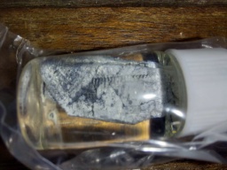 Heavily oxidized chunk of Potassium metal in a bottle of oil, itself in what appears to be a sealed bag