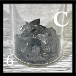 Shiny chunks of Carbon in a bottle. It's hard to tell if these chunks are the graphite or glassy form.