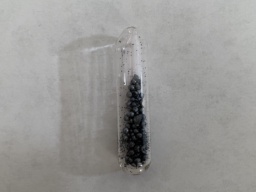 A few dozen pellets of Iodine in an ampoule. The inside is also covered with countless tiny flecks of Iodine.