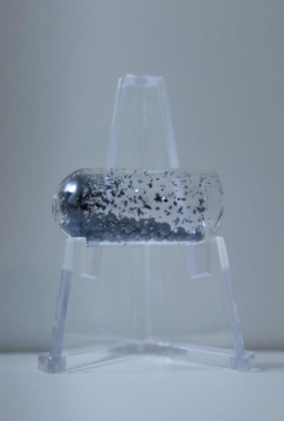 1 gram of dark purple Iodine pellets in an ampoule, resting on a clear folding stand