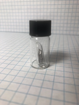 Small piece of dull gray Thallium metal in an ampoule, itself in a bottle. Despite looking innocent, |tl| is arguably the most poisonous chemical element, even more so than |as|. Even holding this metal is a terrible idea, because it can get through your skin!