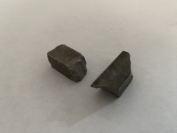 Two chunks of dark Tungsten metal