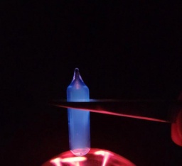 Ampoule of low pressure Mercury vapor on top of a plasma globe, glowing a blue color