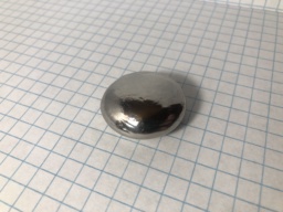 Roughly 3.5 cm diameter chunk of Niobium metal, shaped somewhere between disc and a sphere.