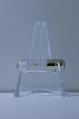 1 gram of solidified Cesium in an ampoule, resting on a clear folding stand