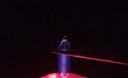 One larger and one smaller ampoule of Hydrogen gas on top of a plasma globe, glowing a purple-blue color