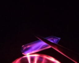 An ampoule of Nitrogen gas on top of a plasma globe, glowing a violet color