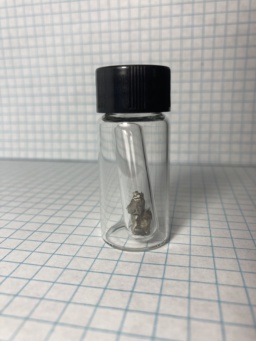 Small shiny piece of Neodymium metal, in an ampoule which itself is in a small bottle. |nd| is a rare-earth metal and should not be confused with the transition metal |nb|.