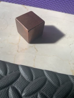 A copper cube measuring 25.4mm (1") on each side, purchased from a metaphysical store. The text around the square reads, clockwise from the top: COPPER / 8.92 g/cc / 5 OUNCES / 1085°C. The square icon itself reads: 29 / Cu / 63.55.