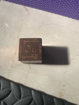 A copper cube measuring 25.4mm (1") on each side, purchased from a metaphysical store. The text around the square reads, clockwise from the top: COPPER / 8.92 g/cc / 5 OUNCES / 1085°C. The square icon itself reads: 29 / Cu / 63.55.