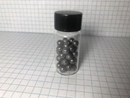 Roughly two dozen spheres of dark, polished Lead shot in a bottle.