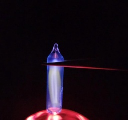 Ampoule of Iodine vapor on top of a plasma globe, glowing a white-blue color