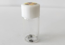 Tiny piece of dull Thorium metal in a small bottle