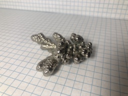 A single crystal of Nickel metal. It looks like a tree branch made of small bubbles joined together. A very cool sample of this somewhat common metal!