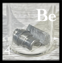 A machined piece of Beryllium and a chunk in a bottle