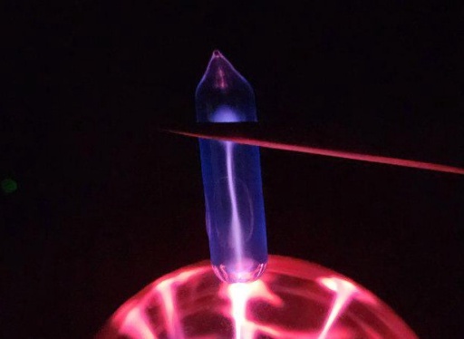 Ampoule of Xenon gas on top of a plasma globe, glowing a violet-magenta color