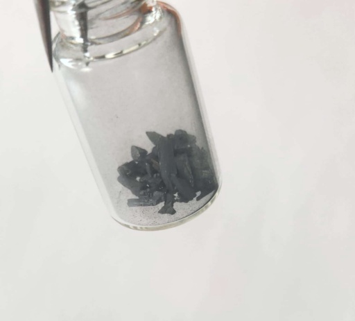 Tellurium can be commonly found in two allotropes (elemental forms): brittle silvery crystals, and amorphous (lack of a molecular structure) dark gray powder. The first photo is a bottle of small, dark gray, amorphous chunks, and the second photo is a bottle of brittle, shiny, silvery chunks.