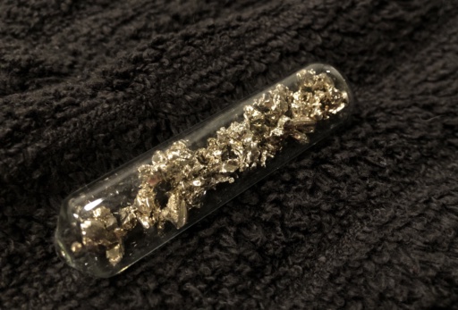 Shiny crystals of slightly golden Calcium metal in an ampoule.