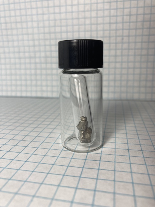 Small shiny piece of Neodymium metal, in an ampoule which itself is in a small bottle. |nd| is a rare-earth metal and should not be confused with the transition metal |nb|.