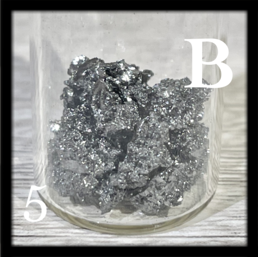 Dark, shiny chunks of crystalline Boron in a bottle