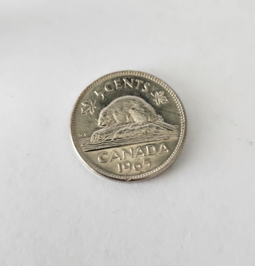 5-cent Canadian coin from 1965. The Canadian and American 5-cent coins are called "nickels," but most of the time they are only plated with Nickel metal, and most of the mass is other metals. However, this Canadian nickel coin from 1965 is made from mostly pure Nickel metal according to the Wikipedia article on Canadian nickel coins.