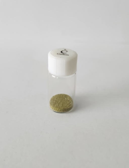 1 gram of diamonds, roughly the size of sand grains, in a tiny plastic bottle. Despite being very pure, very trace amounts of impurities color the sample yellow