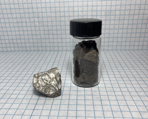 A small shiny chunk of Manganese metal, and heavily oxidized pieces in a small jar