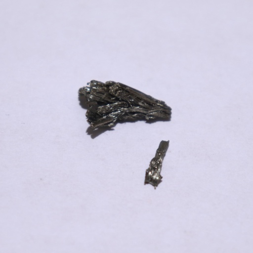 One large and one small piece of shiny dendritic (hair-like) Scandium metal