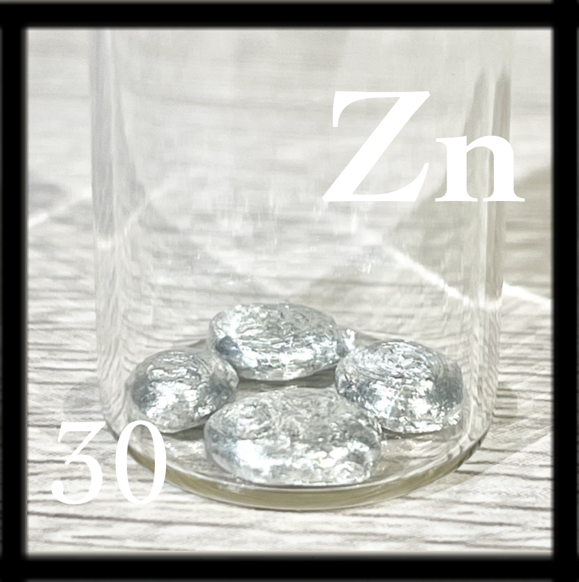 Four small, shiny discs of Zinc in a bottle