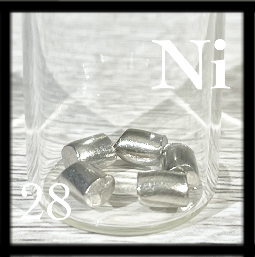 Five shiny, small pellets of Nickel in a bottle