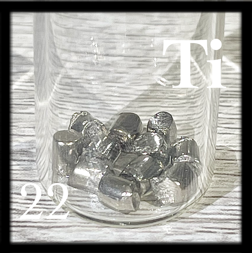 Small, shiny pellets of Titanium in a bottle